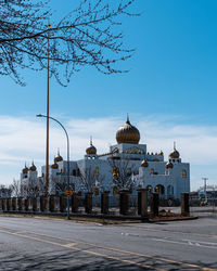 View of buildings in city against blue sky