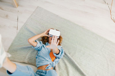 Midsection of woman using mobile phone while sitting on bed