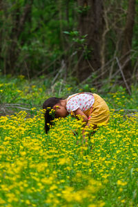 Girl with yellow flowers on field