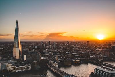 Aerial view of buildings in city during sunset