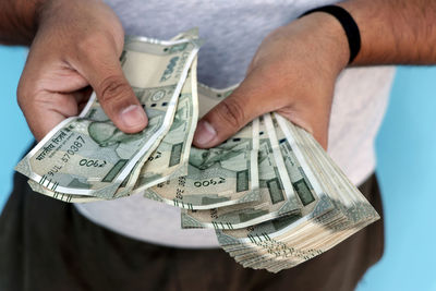 Midsection of man holding paper currency