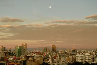 Buildings in city against sky during sunset