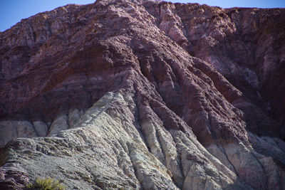 Low angle view of rocky mountains against sky