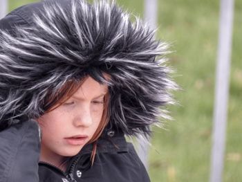 Close-up of thoughtful girl wearing fur coat