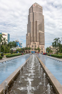 Wet road amidst buildings in city during rainy season