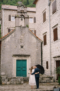 Rear view of woman standing outside building