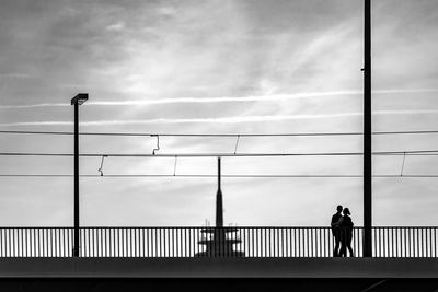 Low angle view of man walking on bridge against sky