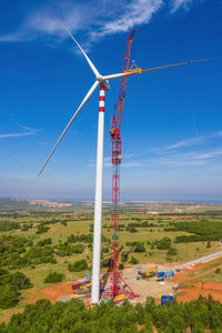 Windmill on field against sky