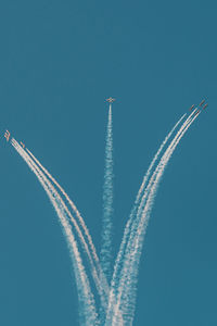 Low angle view of vapor trail against clear blue sky