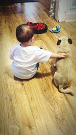 High angle view of man playing with dog at home