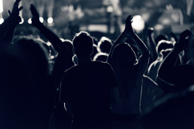 Silhouette people at music concert against sky at night