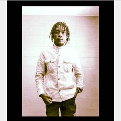 Portrait of young man standing against wall