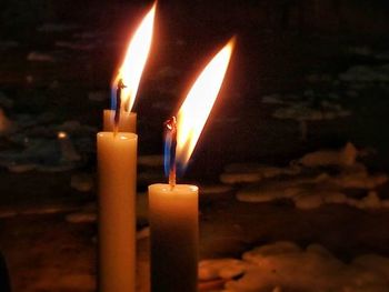 Close-up of lit candle in dark room