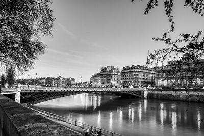 Bridge over river in city against sky