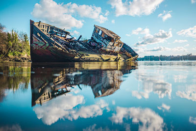 Graffiti on abandoned boat against sky