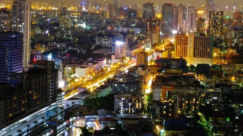 High angle view of illuminated city street and buildings at night