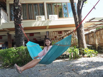 Portrait of smiling woman sitting on hammock