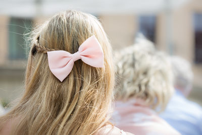 Rear view of woman wearing pink tied bow in hair