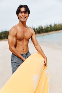 Portrait of shirtless man standing on beach