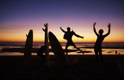 Silhouette of people at beach during sunset
