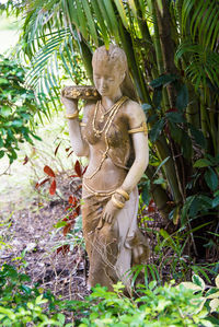 Statue of woman in forest
