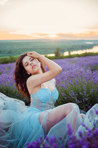 A beautiful young girl against the sunset and a beautiful sky in a lavender field. 