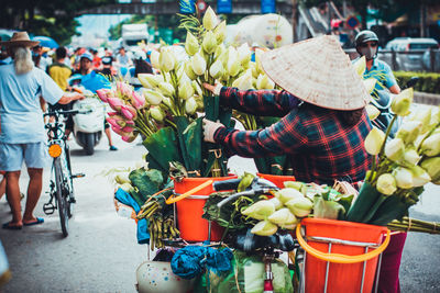 Woman with flowers for sale market stall in city
