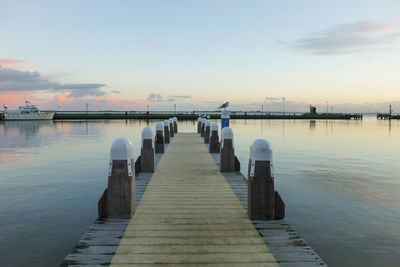 Pier leading to wooden posts in sea