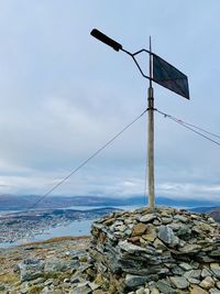 Crane on rock against sky