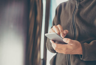 Midsection of man using mobile phone