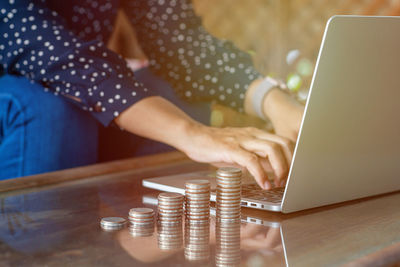 Midsection of woman using mobile phone on table