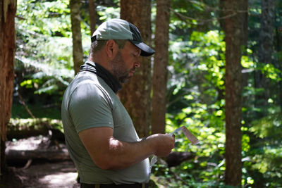 Side view of man standing in forest