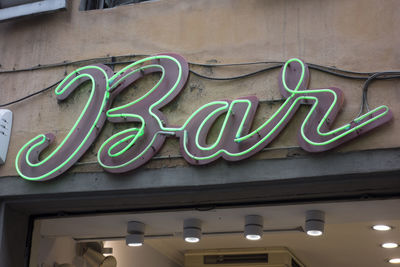 Low angle view of illuminated text on wall