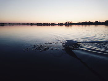 Reflection of trees in water at sunset