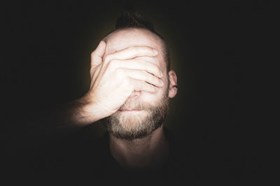 Close-up of man against black background