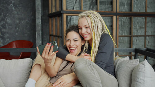 Happy young woman sitting on mobile phone