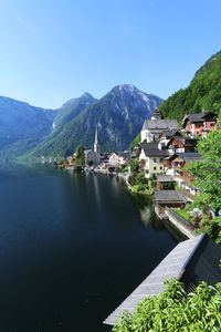 Scenic view of buildings and mountains against blue sky