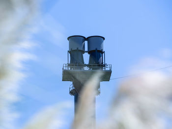 Low angle view of factory against blue sky