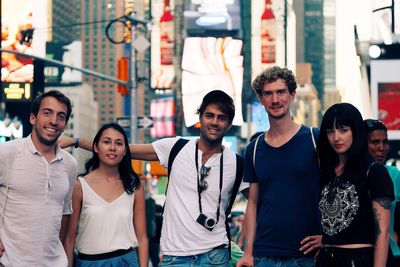 Portrait of friends against buildings in city