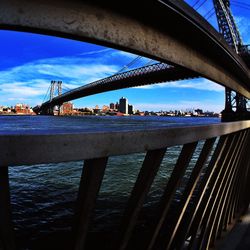 Bridge over river against cloudy sky
