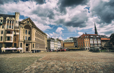 Buildings in city against cloudy sky