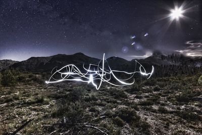 Light painting on field against sky at night