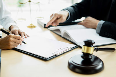 Midsection of man and woman sitting on table