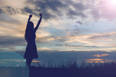 Silhouette person standing on field against sky during sunset