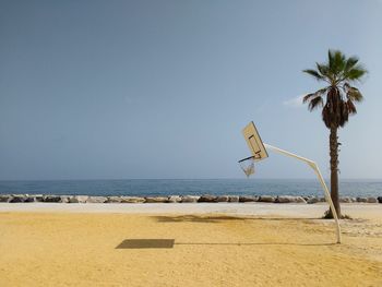 Basket court on beach against clear sky