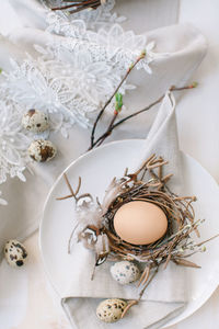 High angle view of eggs and nest in plate on table