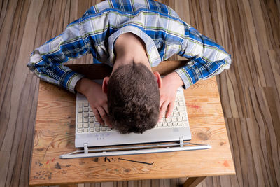 High angle view of man lying on wooden floor