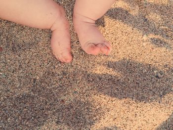 Low section of baby at sandy beach