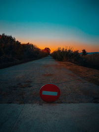 Road sign against sky during sunset