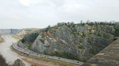 Scenic view of river by mountains against sky